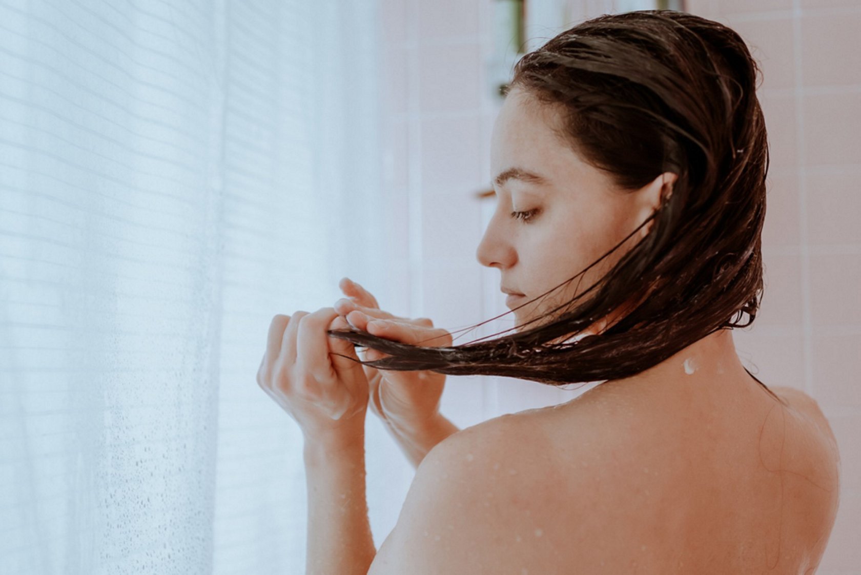 Front Page -Haircare Products Sale Young brunette woman washing her hair in the shower